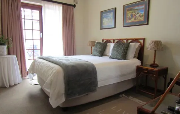 Cozy bedroom with a bed side tables lamps and two framed pictures on the wall
