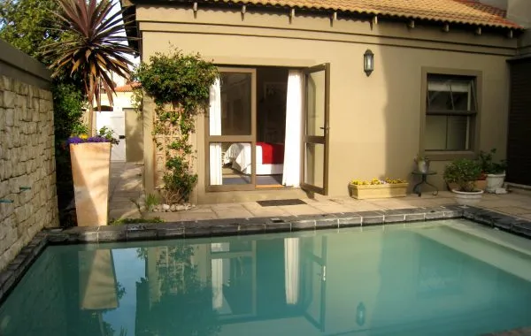 Swimming pool in a backyard with a house and plants