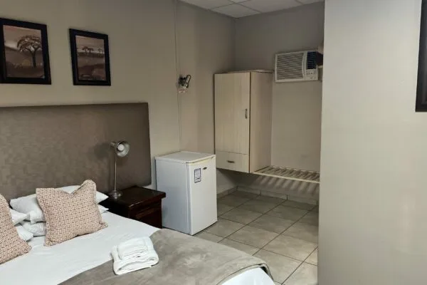 Bedroom with double bed mini fridge wardrobe and wall art