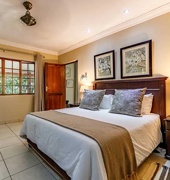 Cozy bedroom with a large bed two framed pictures and a ceiling fan