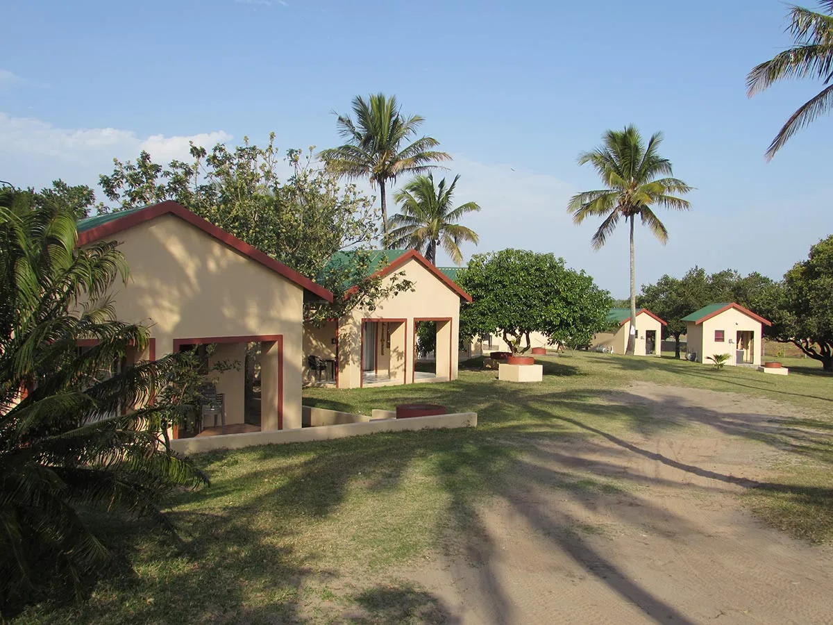 Row of small colorful buildings with red roofs in a tropical setting