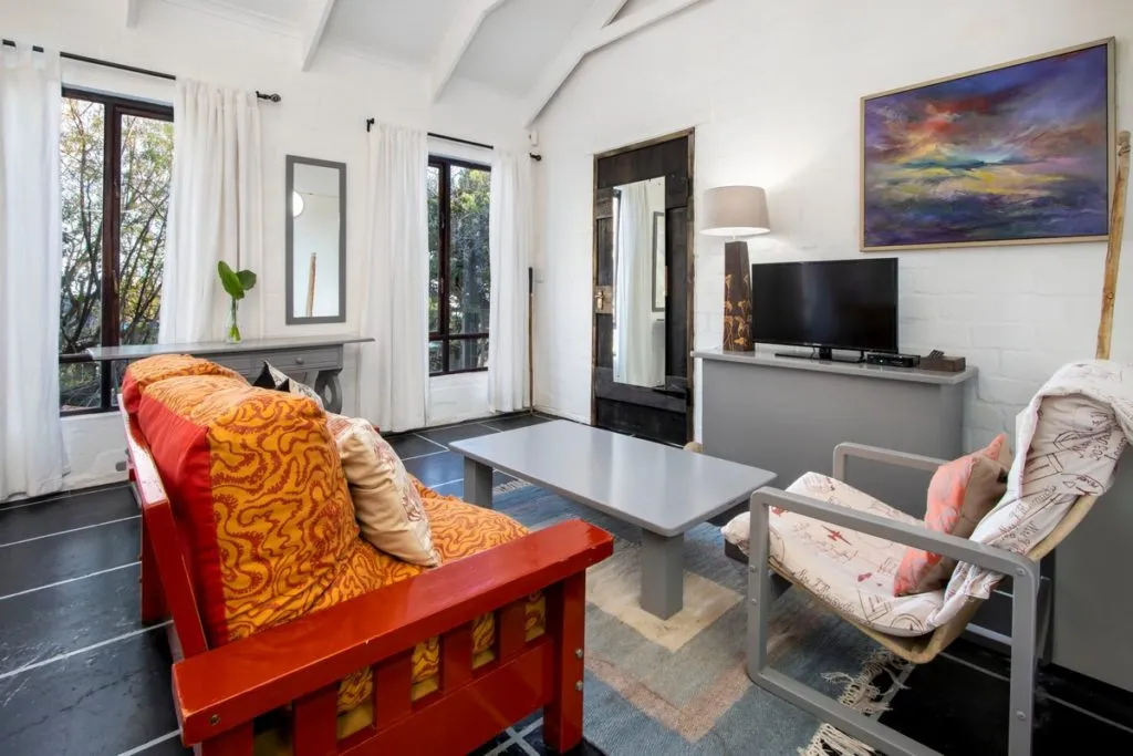 Cozy living room with colorful furniture TV and large windows