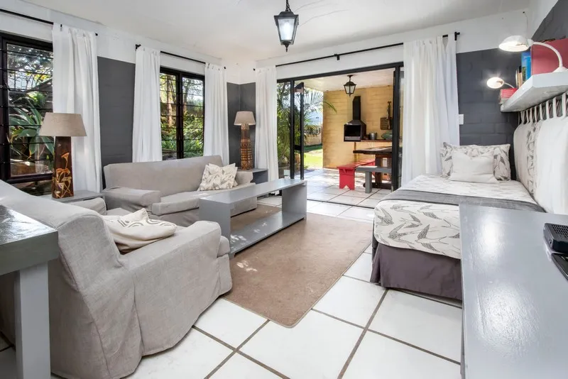 Living room with gray furniture large windows and an open patio view