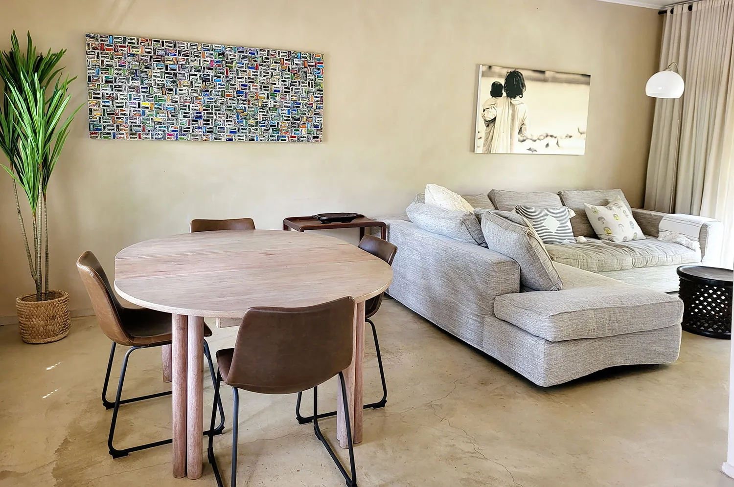 Modern living room with round wooden table chairs sofa and wall art