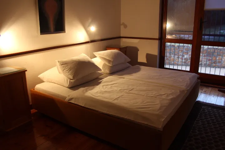 Cozy bedroom with a large bed wooden floor and warm lighting