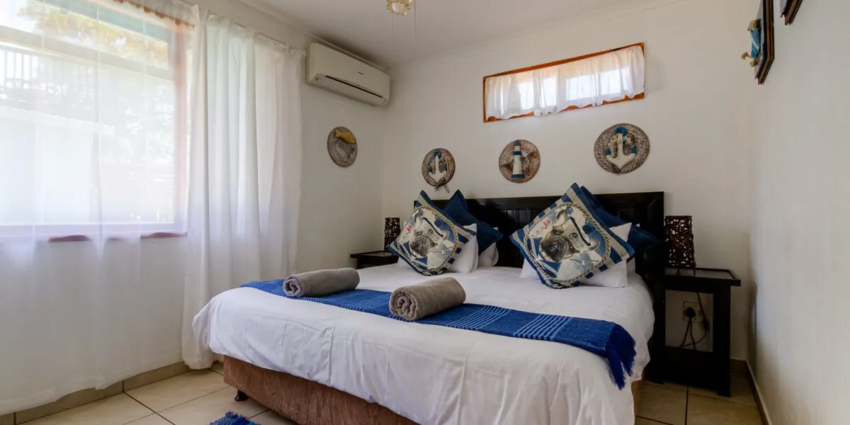 Neat bedroom with a double bed white walls and nauticalthemed decor