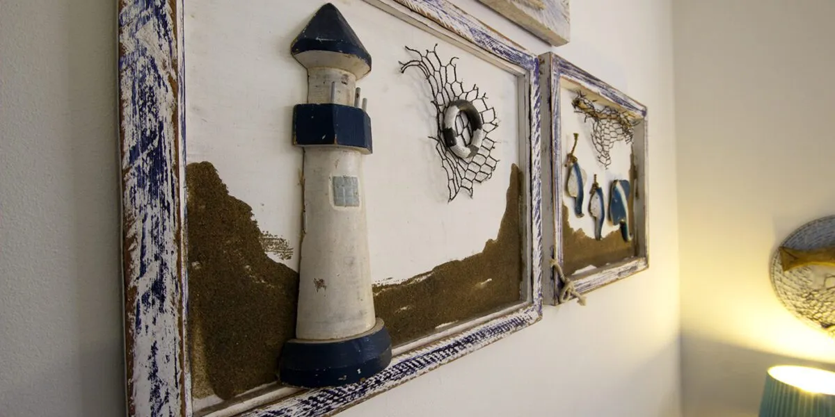 Wooden wall art with lighthouse and seathemed decorations on white wall