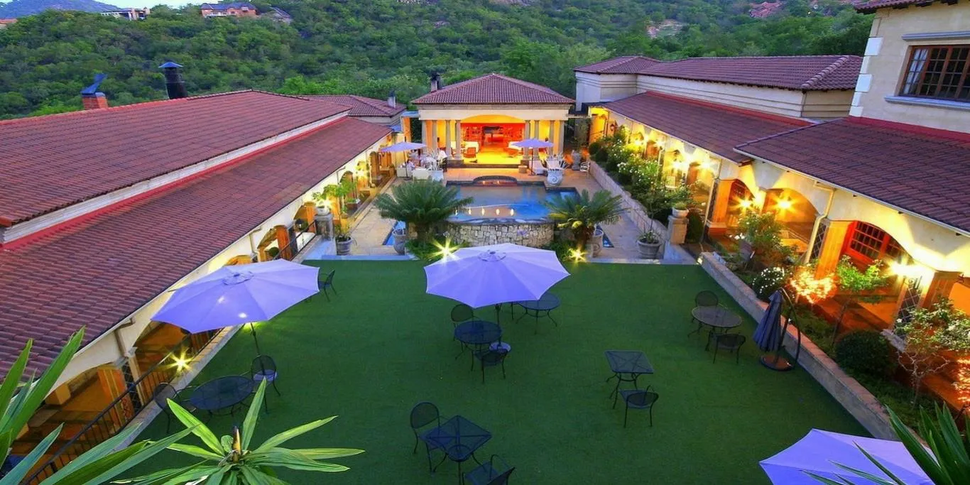 Courtyard with pool tables chairs and umbrellas surrounded by buildings and greenery