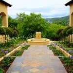 Pathway with fountain surrounded by greenery and flowers in a garden setting