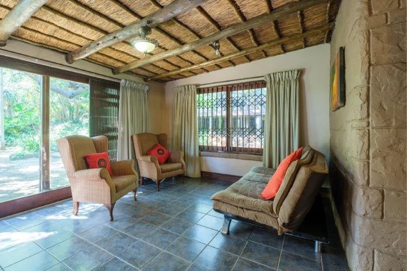 Cozy living room with armchairs sofa and large windows with bars