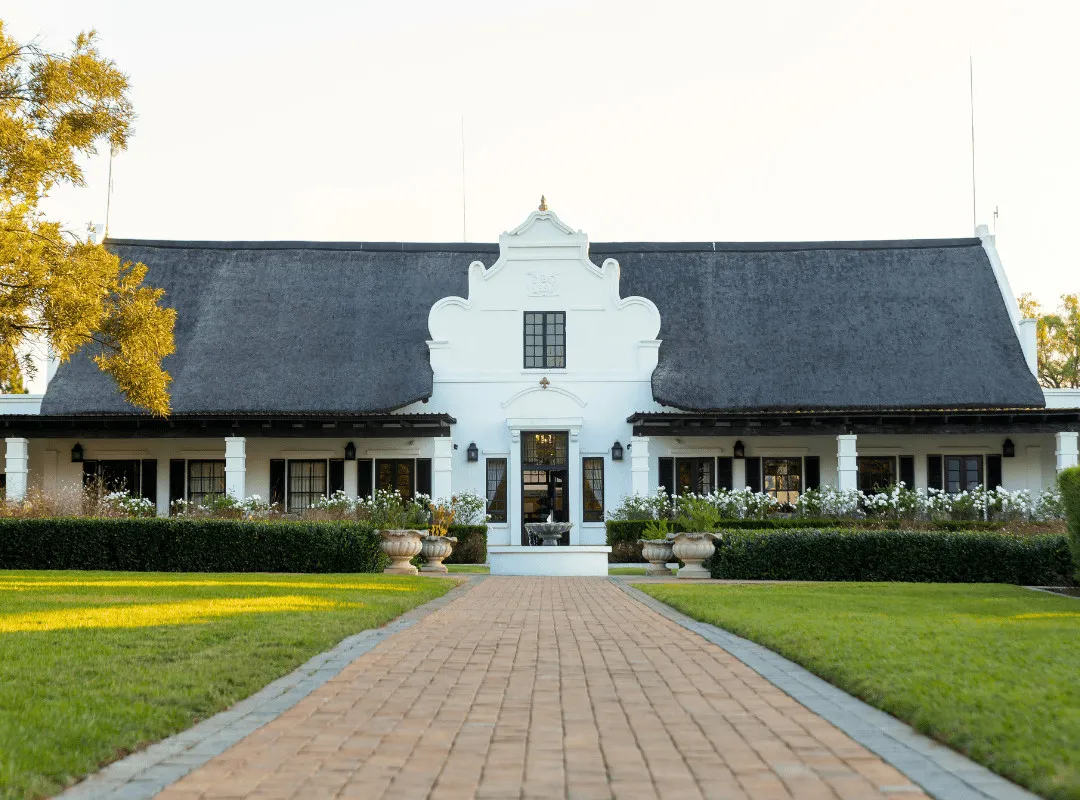 White building with a thatched roof symmetrical design and a central entrance