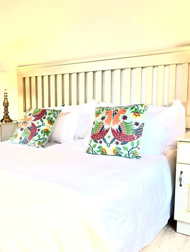 Bed with white sheets and colorful decorative pillows in a bedroom