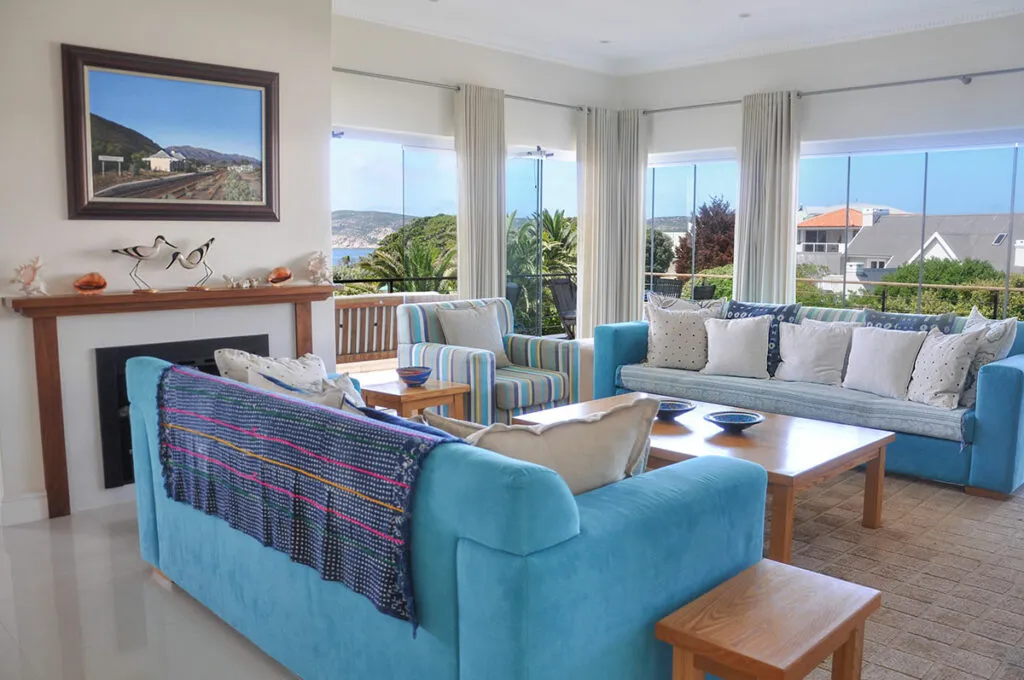 Bright living room with blue sofas large windows and a fireplace