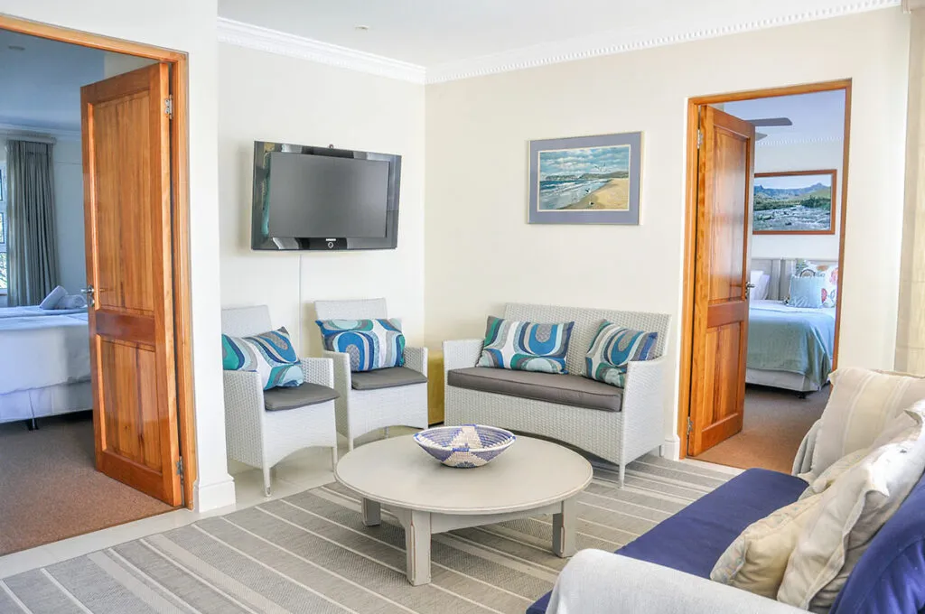 Living room with TV sofa chairs and open doors to other rooms