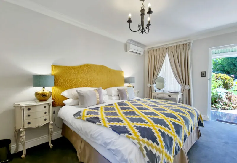 Cozy bedroom with a large bed yellow headboard and patterned blanket