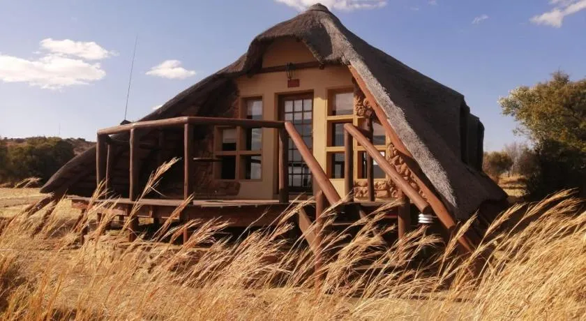 A thatchedroof hut surrounded by tall grass in a rural setting