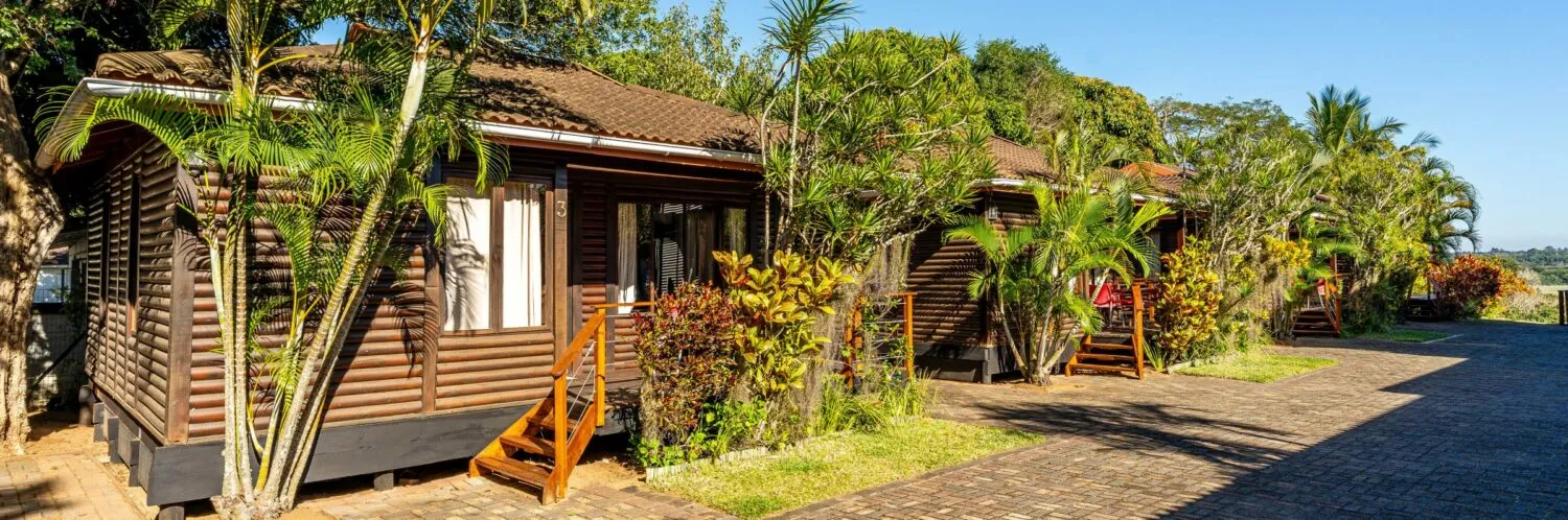 Wooden cabins with tropical plants in a sunny resort setting