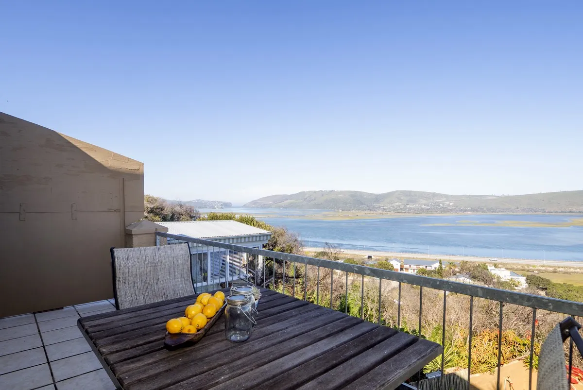 Wooden table with lemons on a balcony overlooking a lake and hills