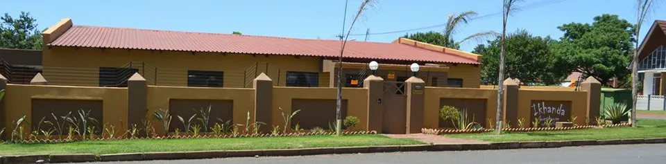 Singlestory building with a red roof and beige wall street view