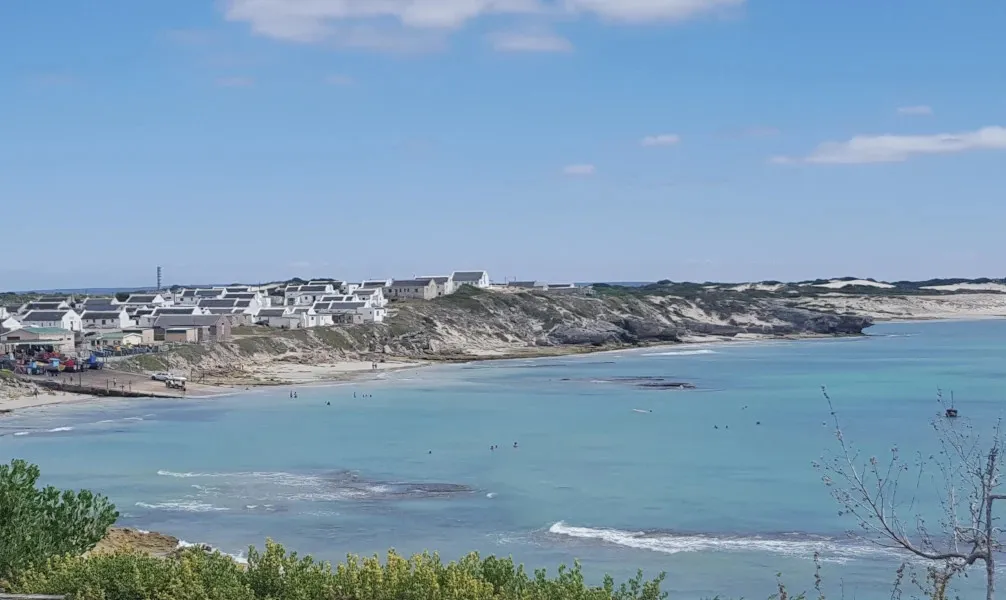 Coastal town with white buildings on cliffs overlooking a blue ocean