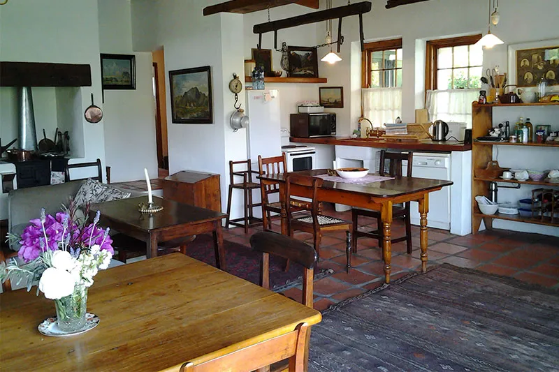Cozy kitchen with wooden furniture flowers and various kitchen appliances