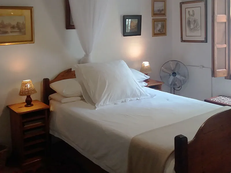 Cozy bedroom with a large white bed bedside lamp and wall art