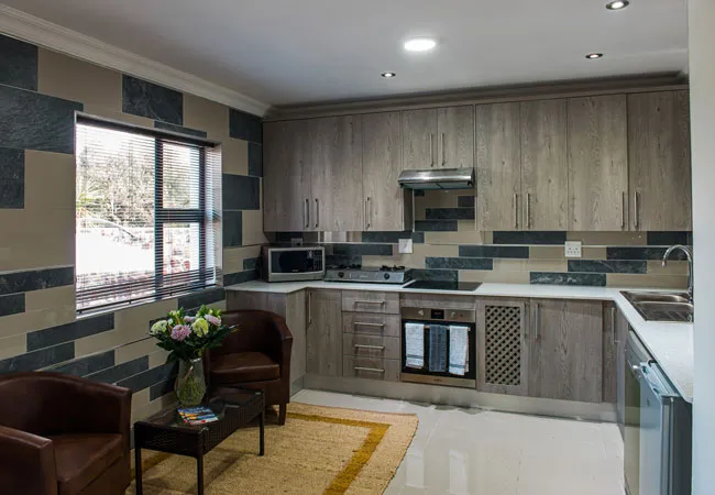 Modern kitchen with wooden cabinets black and white tiles and seating area