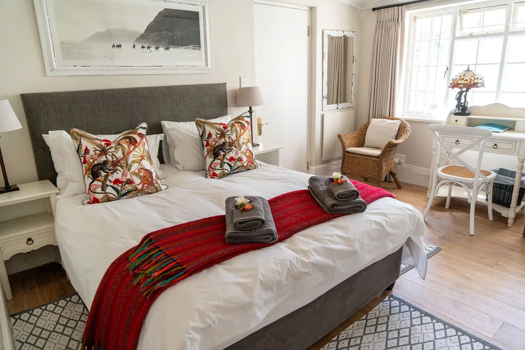 Cozy bedroom with a large bed colorful pillows and wooden floor