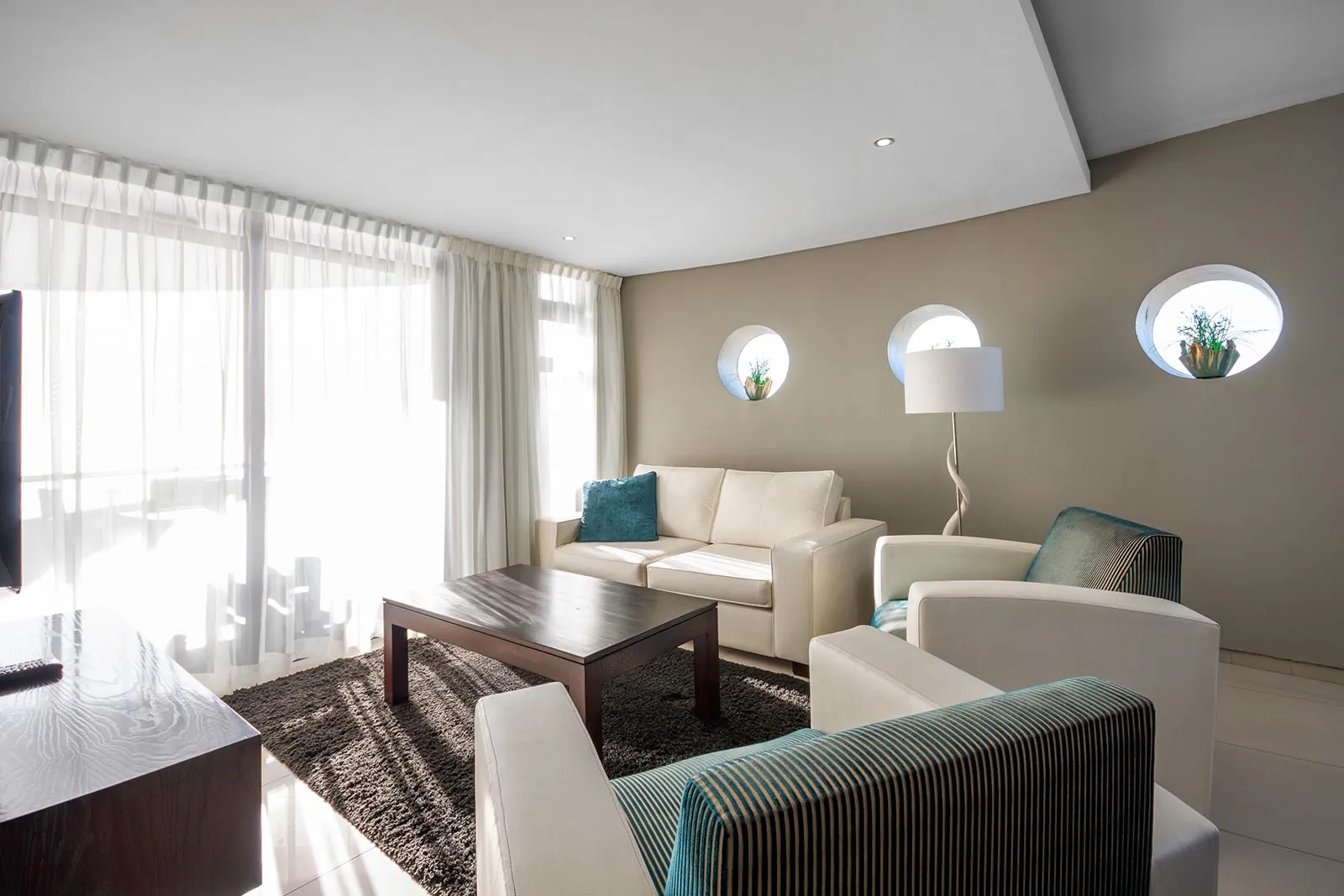 Modern living room with white sofas large windows and decorative wall circles