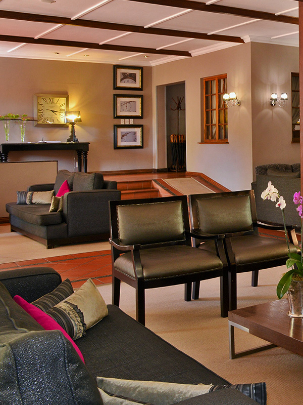 Modern living room with black furniture, wall art, and warm lighting.