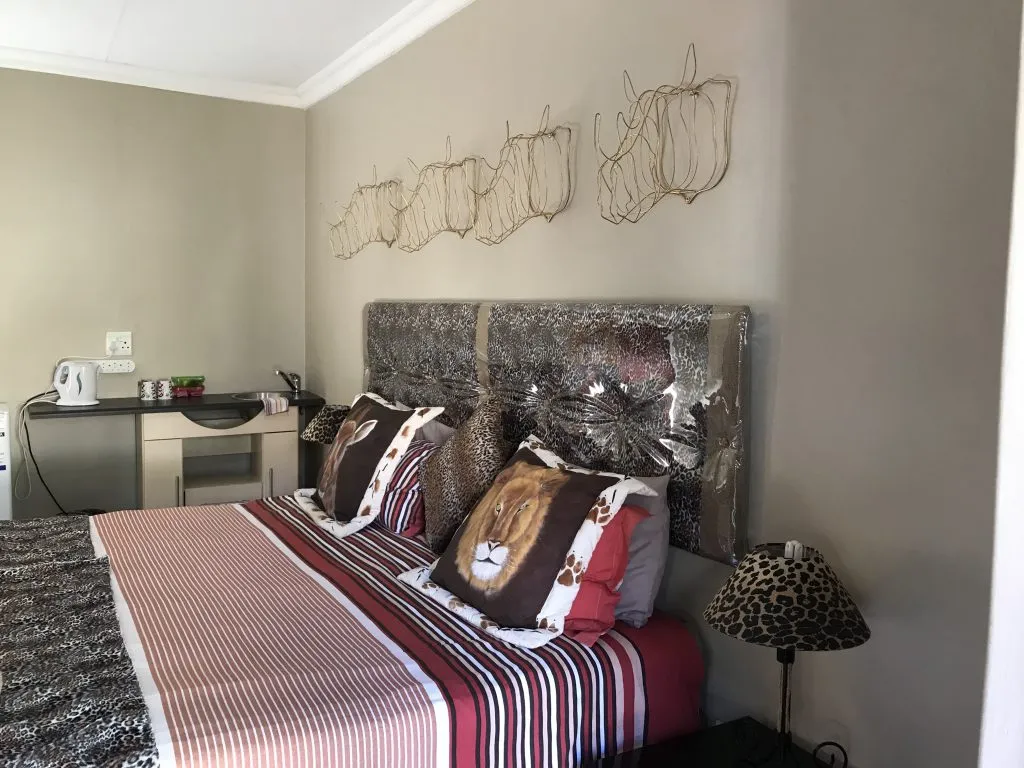 Bedroom with a large bed striped bedding and decorative wall art