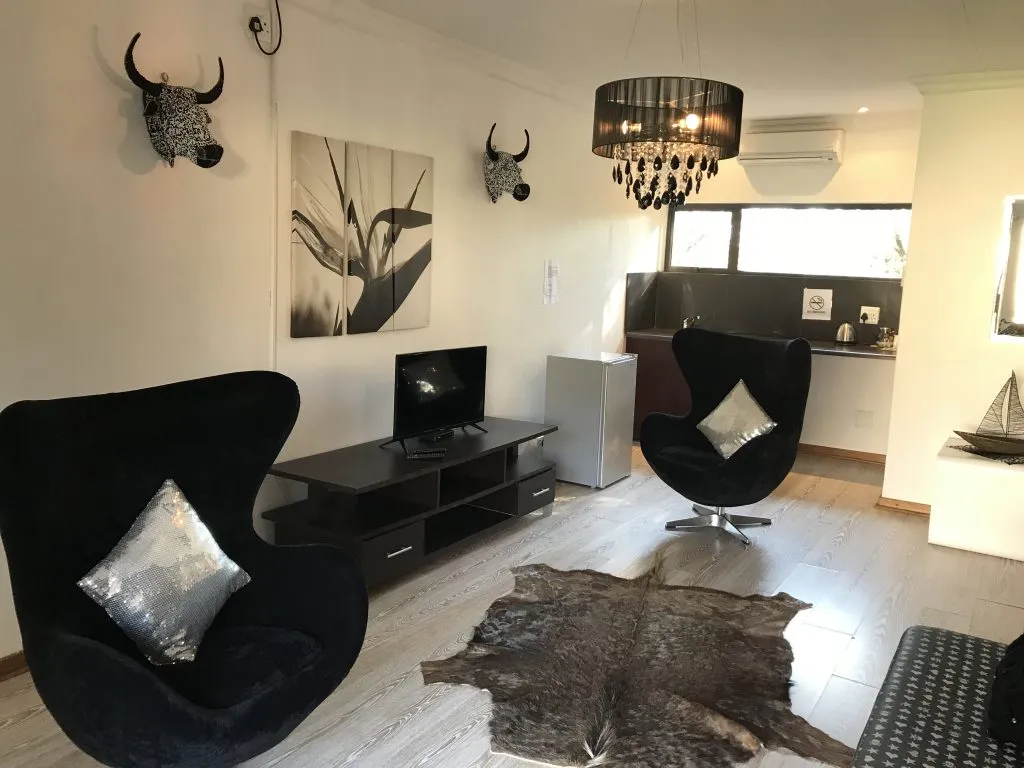 Modern living room with black furniture animal heads on walls and kitchen view
