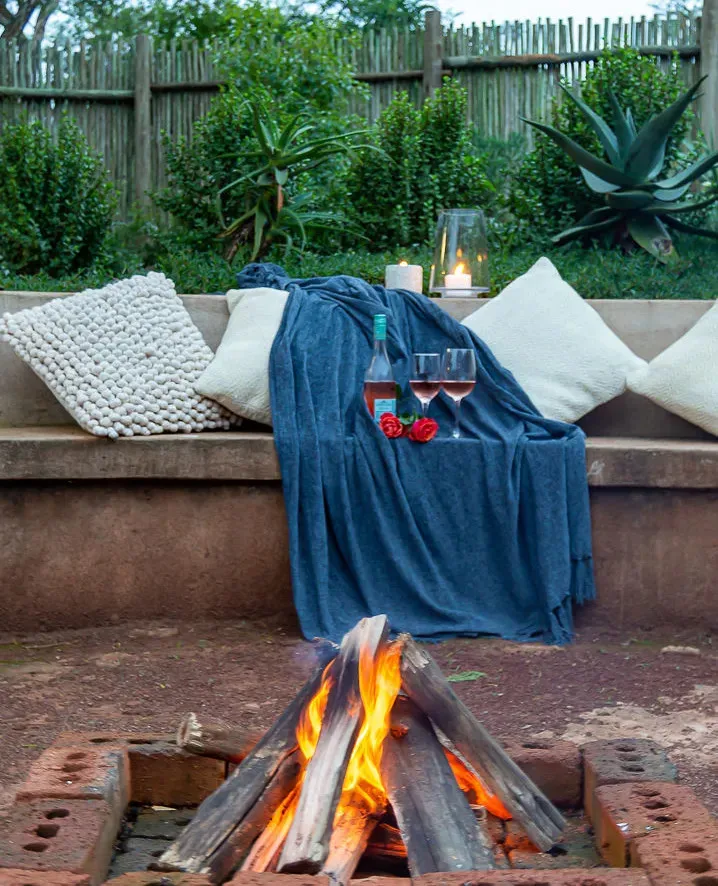 Cozy outdoor seating with wine pillows and a fire pit