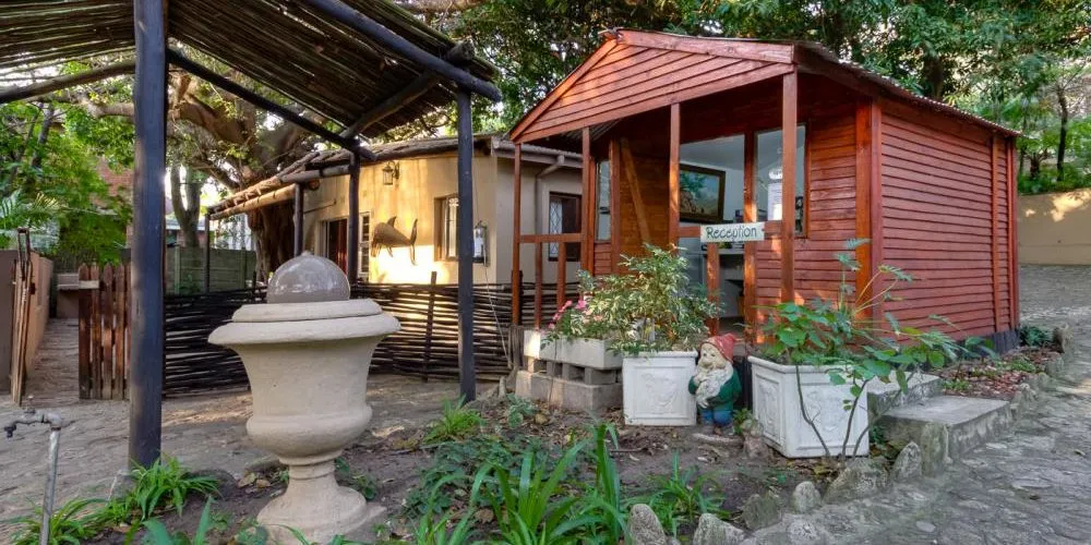 Wooden cabin and stone fountain in a lush garden setting