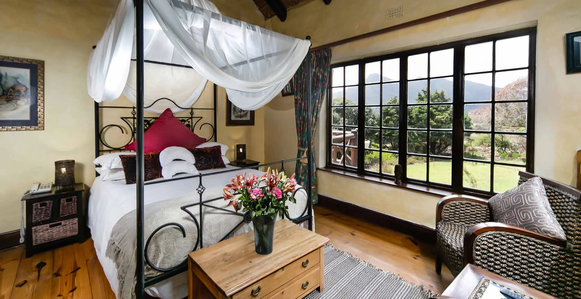 Cozy bedroom with a fourposter bed large windows and garden view