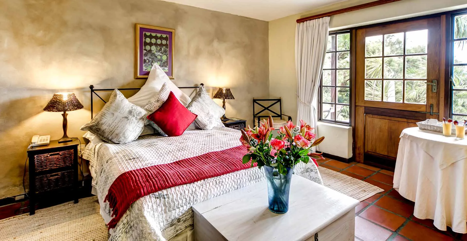 Cozy bedroom with a large bed flowers and a view of a garden