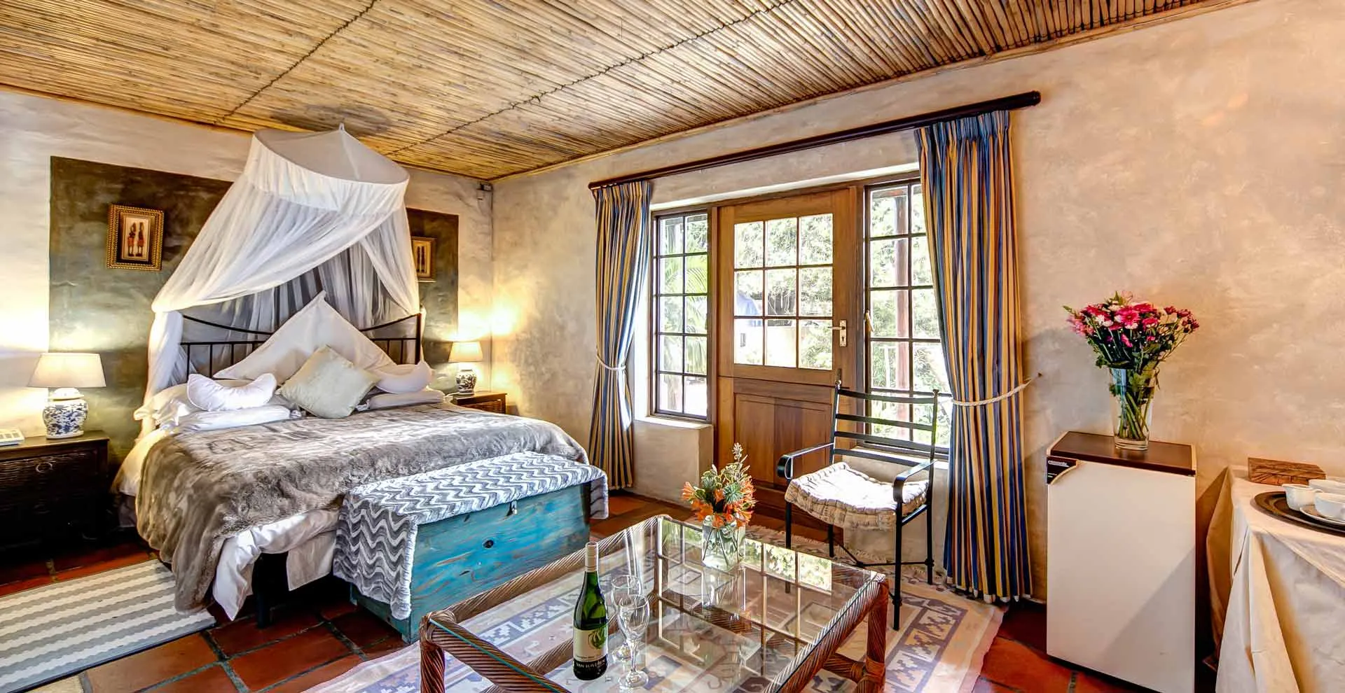 Cozy bedroom with a large bed wooden ceiling and a glass door