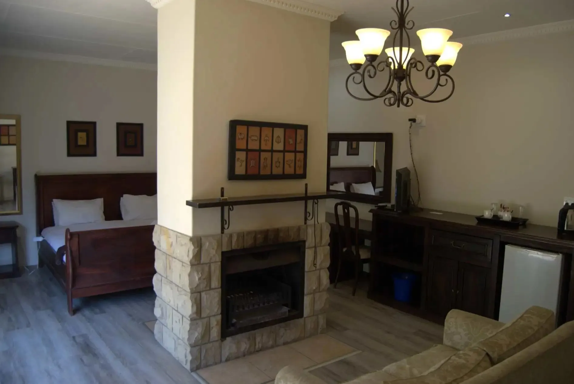 Cozy bedroom with fireplace bed sofa and chandelier