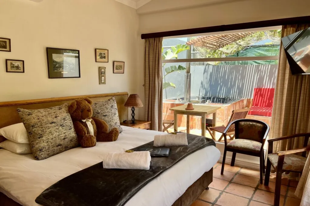 Cozy bedroom with teddy bear on bed and view of outdoor patio