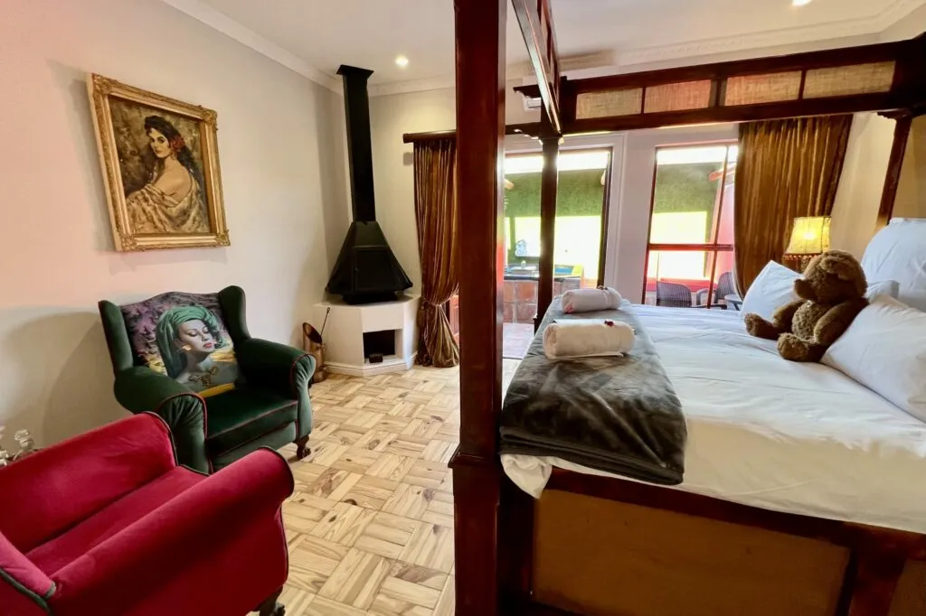 Cozy bedroom with a bed chairs fireplace and large windows