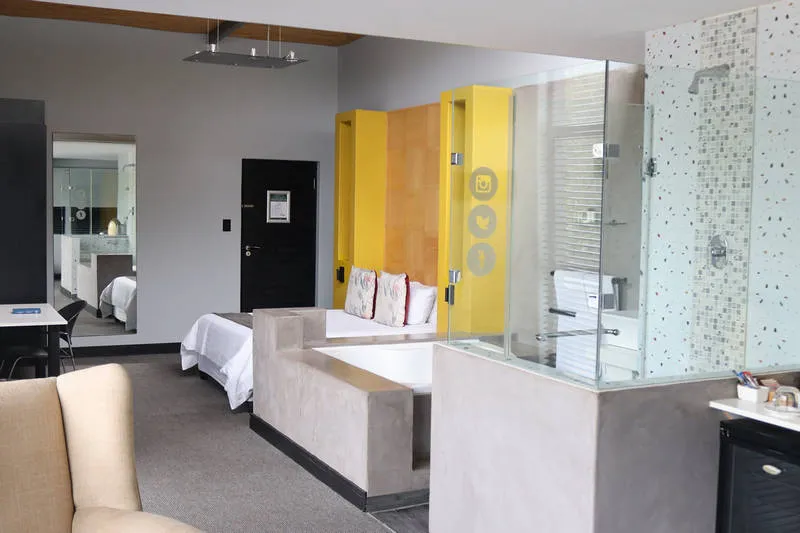 Modern hotel room with bed bathtub and glass shower