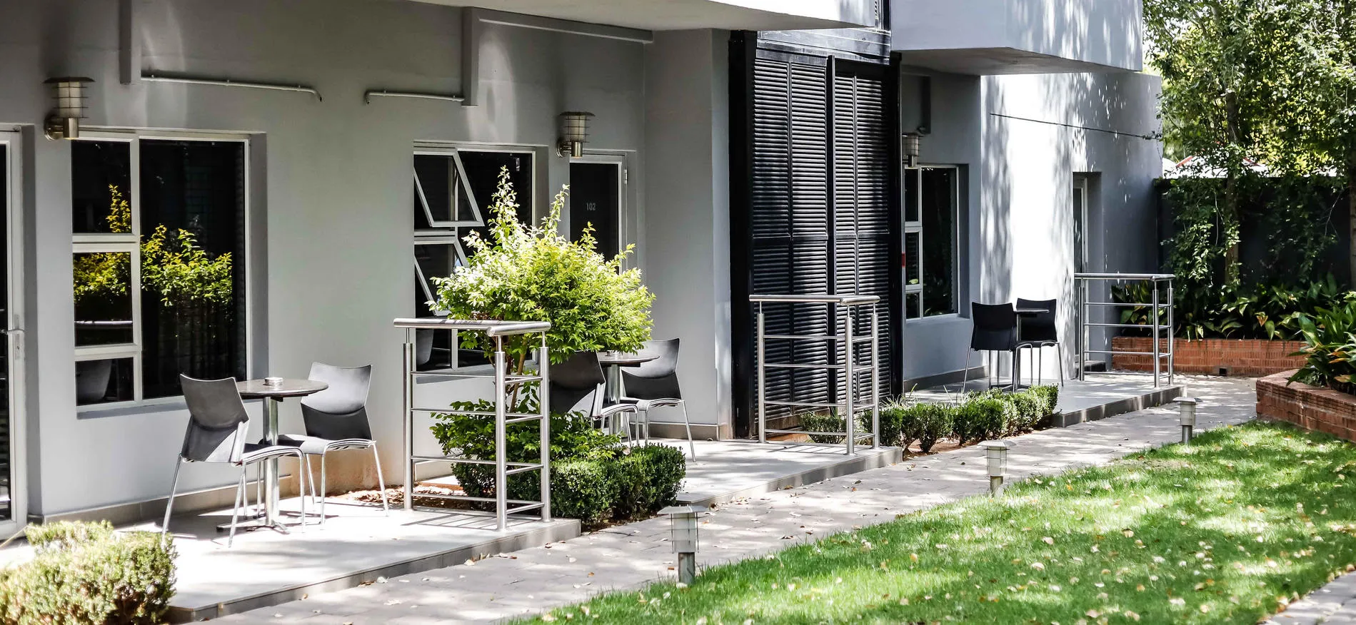 Modern building with outdoor seating area and green lawn