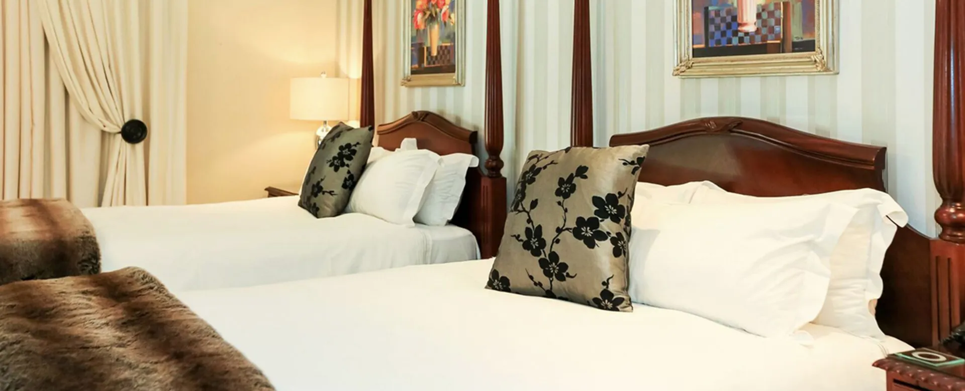 Two neatly made beds with wooden headboards in a hotel room