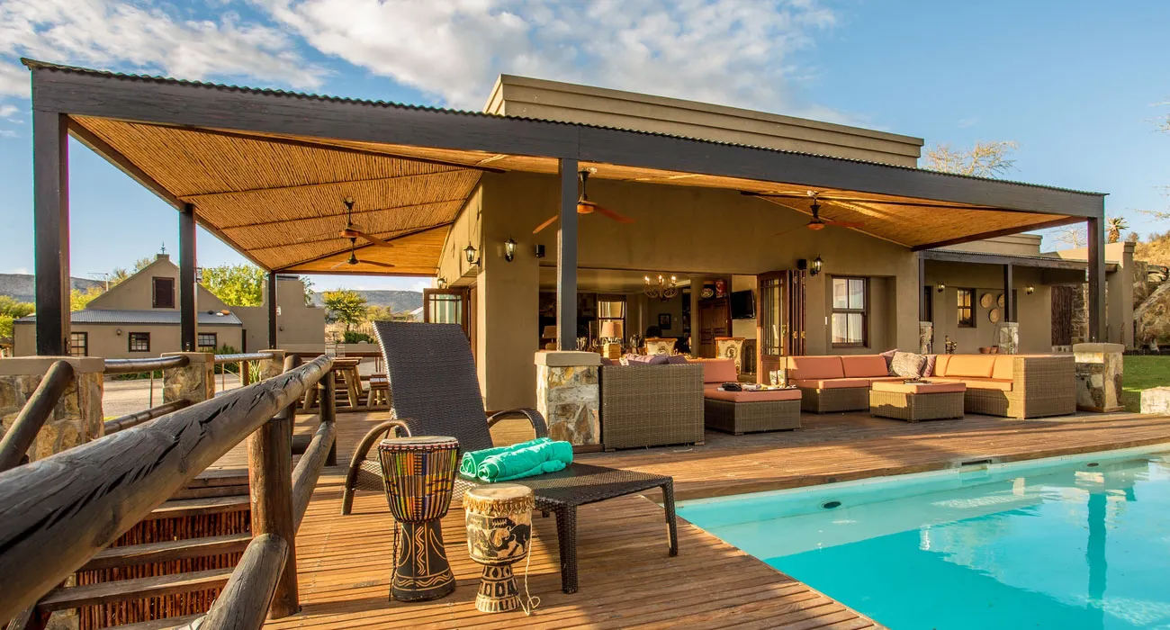 Modern house with wooden deck pool and outdoor lounge area under a pergola