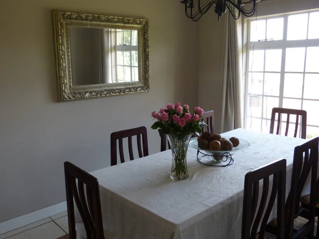 Dining table with floral centerpiece and chairs in a welllit room