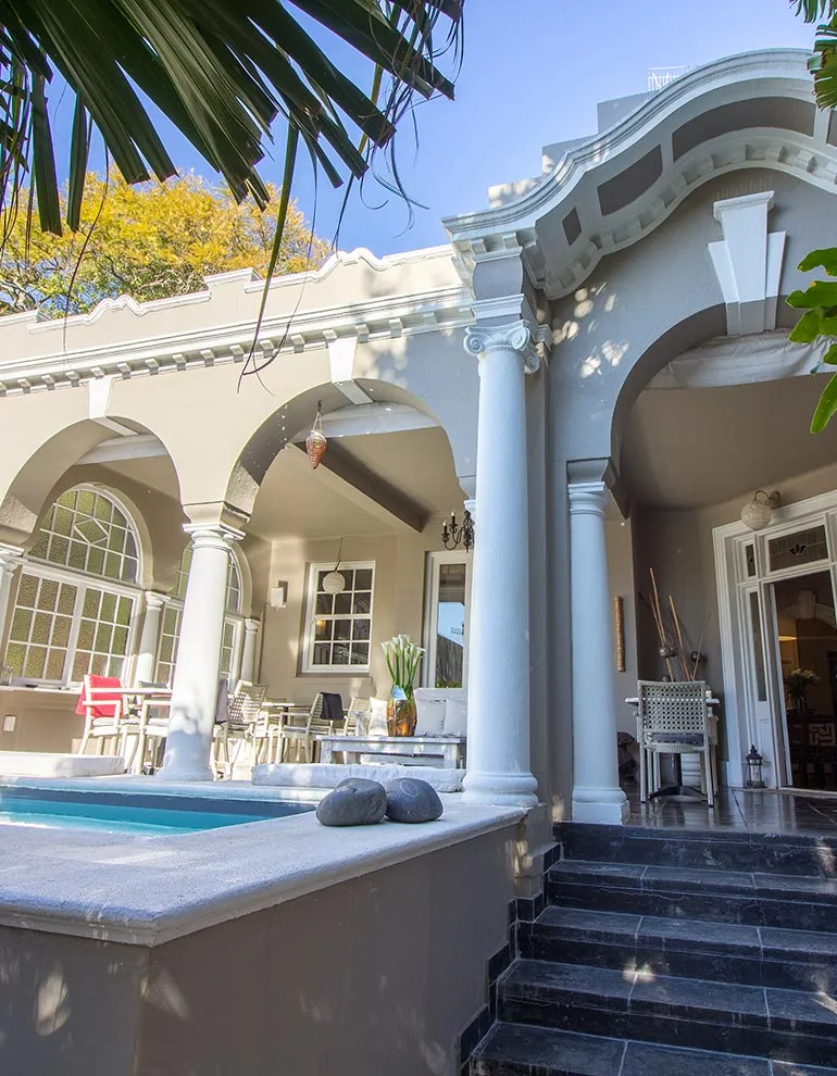 Mediterraneanstyle house with arches columns and a small pool in the courtyard