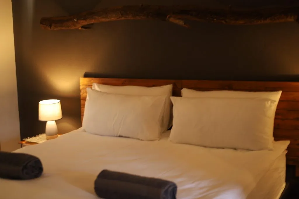 Cozy bedroom with a neatly made bed and a bedside lamp