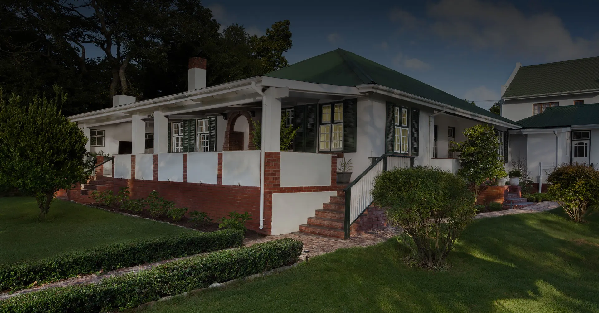 Singlestory house with green roof red brick base and wellmaintained garden