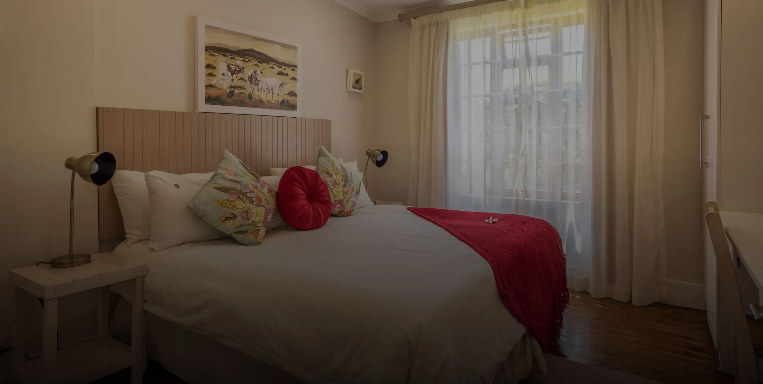 Cozy bedroom with a large bed pillows and a window with sheer curtains