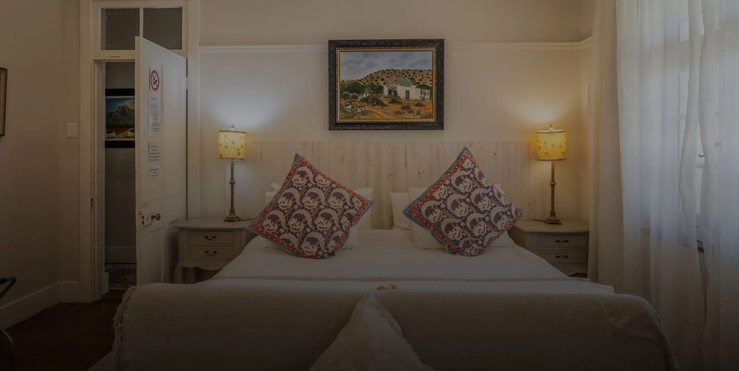 Cozy bedroom with double bed patterned pillows and bedside lamps